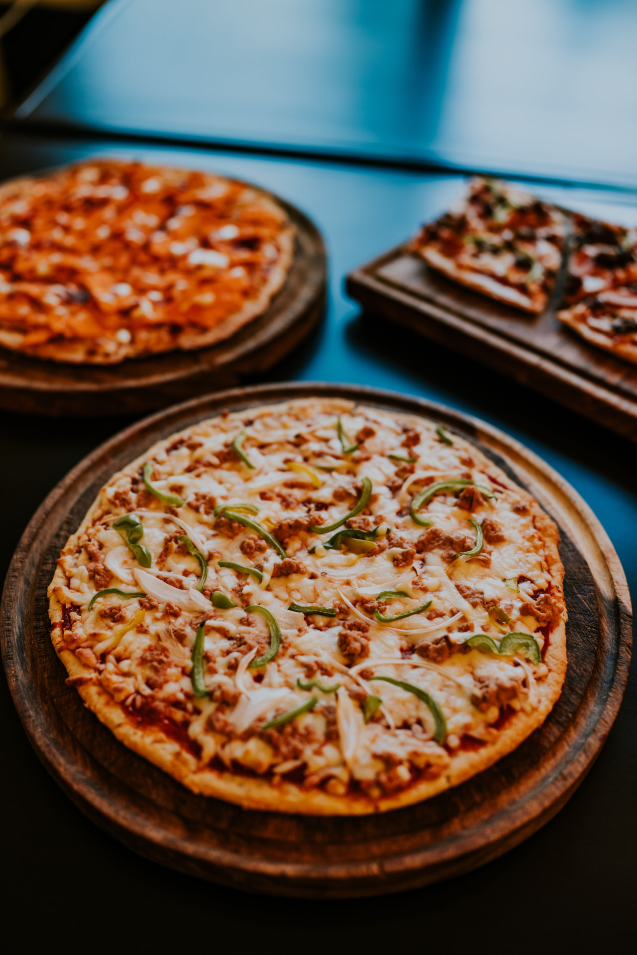 Close-up of fresh pizzas on wooden boards